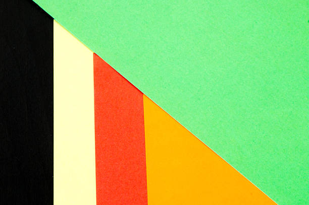 Multicoloured papers overlapped by a green paper