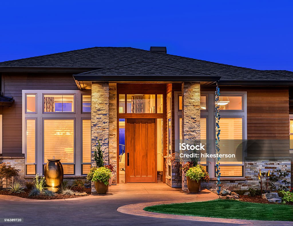 Beautiful Home Exterior at Night Front elevation of luxury home in evening with deep blue sky Residential Building Stock Photo