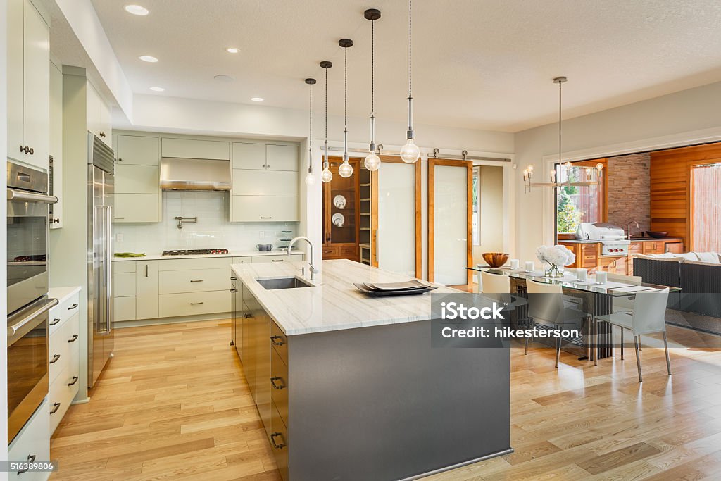 Beautiful Kitchen in New Luxury Home Kitchen with Island, Sink, Cabinets, and Hardwood Floors Kitchen Stock Photo