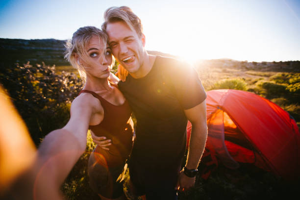 im freien paar genießen sonnenuntergang selfie während wandern und camping auf vaca - humor human face women grimacing stock-fotos und bilder