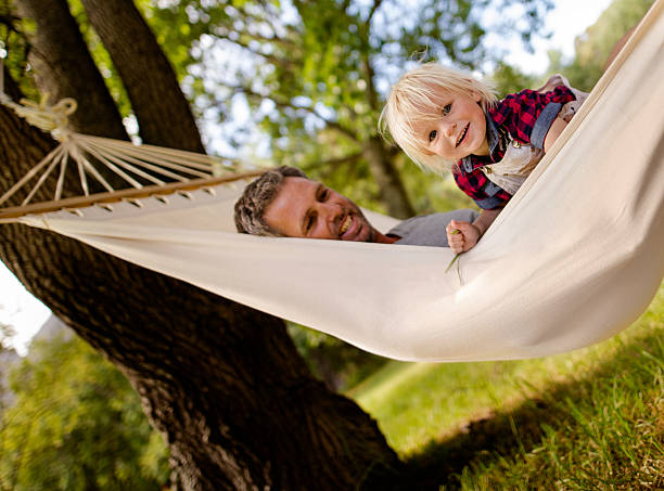 istock Lovely dad hugs his blond child on a hammock 516391880