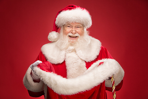 Portrait of senior man in image of Santa Claus posing with winning emotions isolated over white background. Concept of fictional character, holiday, New Year, Christmas. Copy space for ad