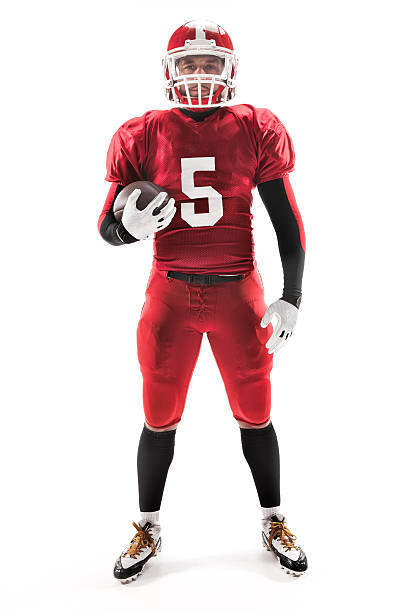 istock American football player posing with ball on white background 516394062