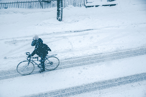Montreal, CA, 7th March 2016. Man riding bike on Rachel Street during snow storm