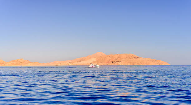 istock Pleasure boat or tour boat off a reef 516395396