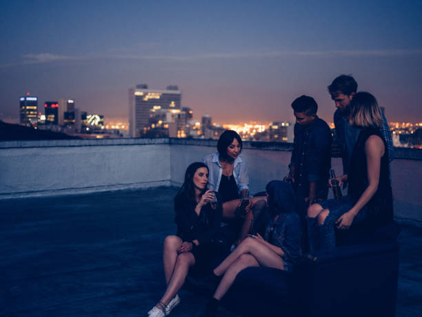istock Hipster friends drinking and talking on a rooftop party 516397122