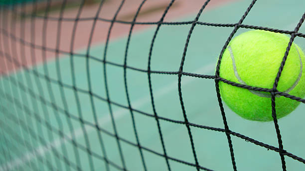 istock Tennis ball in net 516398637