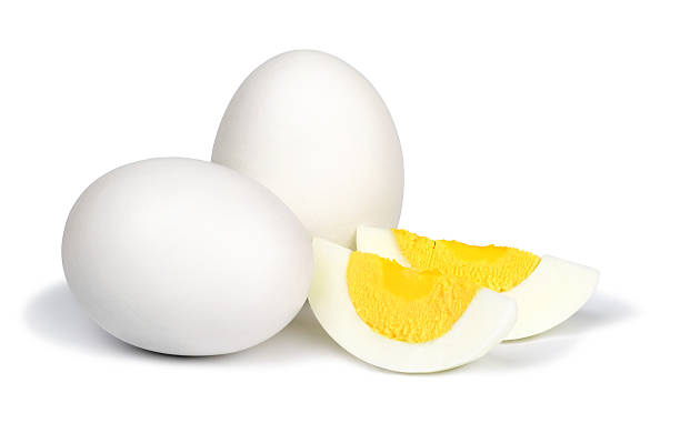 Boiled eggs on white background. Two whole unpeeled boiled eggs and two slices of eggs isolated on a white background. boiled egg cut out stock pictures, royalty-free photos & images