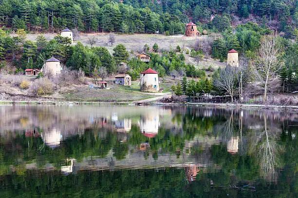 View of stone windmills and forest reflection on water by the Cubuk lake near Goynuk province in Bolu Turkey