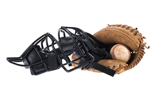 Cather's mask, glove and baseball on a white background A black wire cather's mask sitting next to a worn cather's mitt with a dirty baseball in it, all on a white background catchers mask stock pictures, royalty-free photos & images