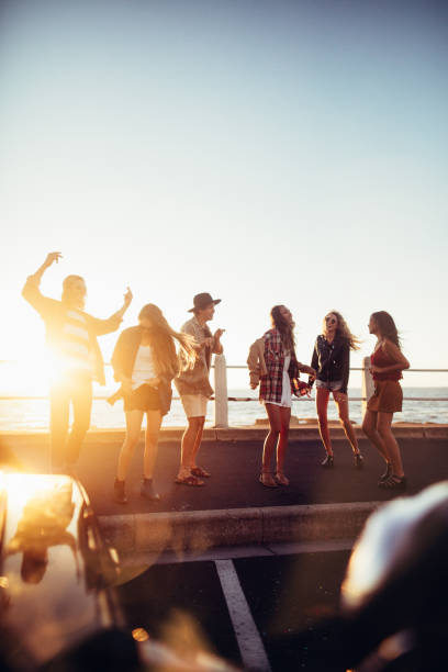 Boho style friends dancing in front of the sea