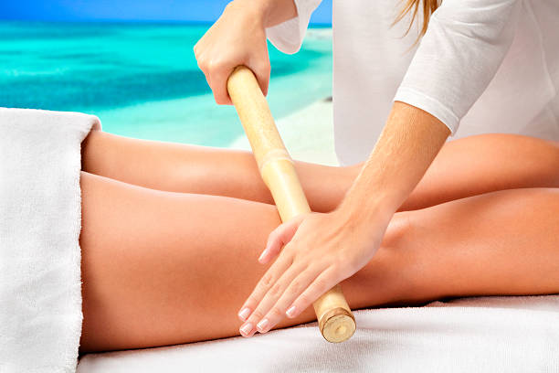 istock Bamboo therapy massage on legs in Caribbean beach Spa 516413031