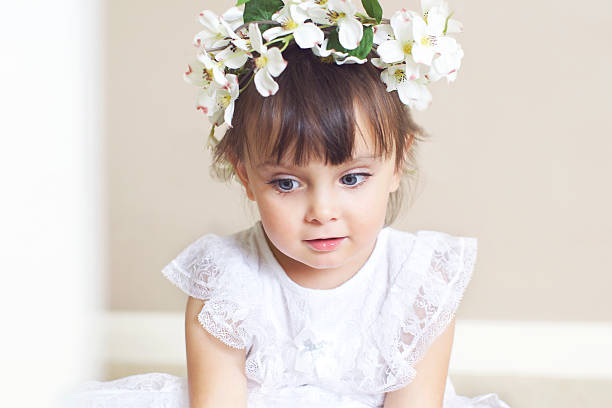 Little Flower Girl Little Girl With a White Dress and Flower Wreath on Head. flower girl stock pictures, royalty-free photos & images