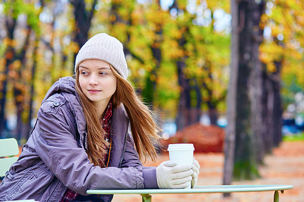 istock Girl drinking coffee or tea outdoors 516415182