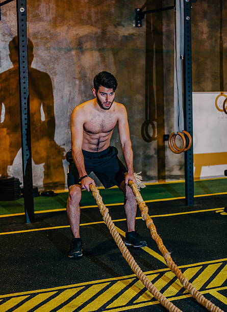 istock Young Man Excerising With Ropes 516415970