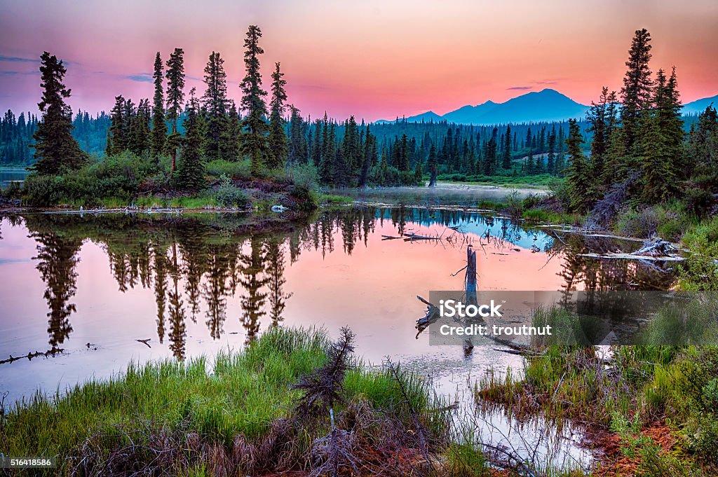 Lake along Nabsna Road A smoky haze hangs over the distant mountains as the sun sets over a lake in Wrangell-St Elias National Park, Alaska Alaska - US State Stock Photo