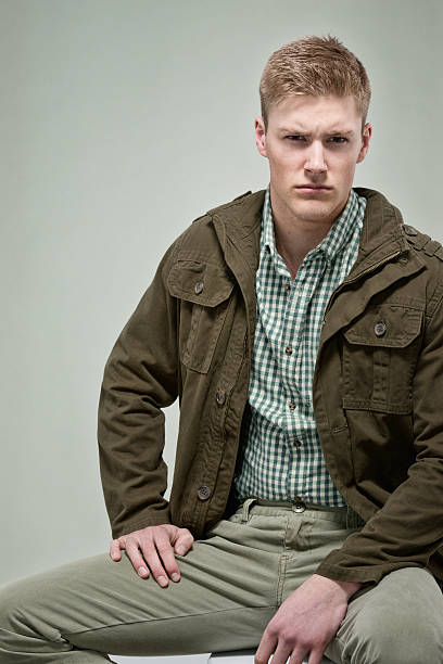 istock Casual man sitting in front of green background 516419248