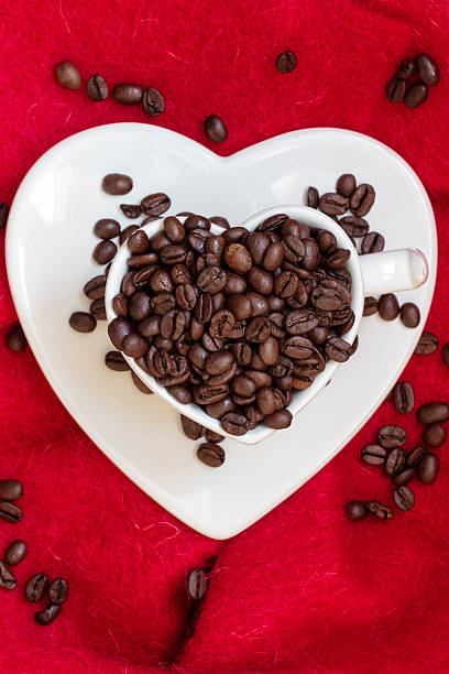 istock Heart shaped cup with coffee beans on red 516420244