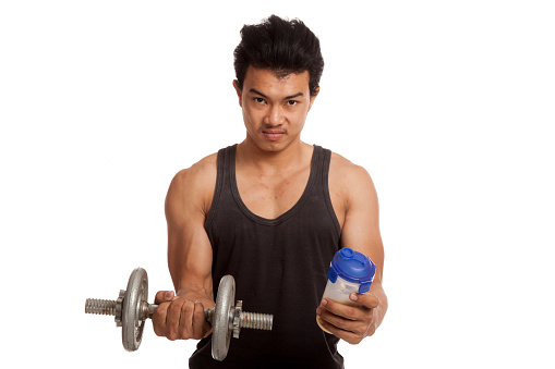 Muscular Asian man with dumbbell and whey protein shakes   isolated on white background