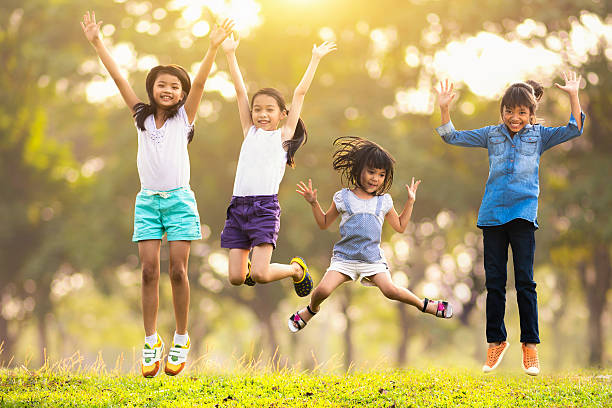 Jumping Joyful happy asian family jumping together at outdoor park air jump stock pictures, royalty-free photos & images