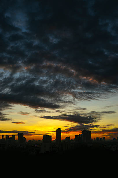 istock Black clouds and city during sunrise 516422418