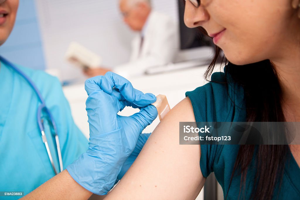 Médecine: Infirmière à pharmacie clinic pour la grippe photo au patient. - Photo de Pansement adhésif libre de droits