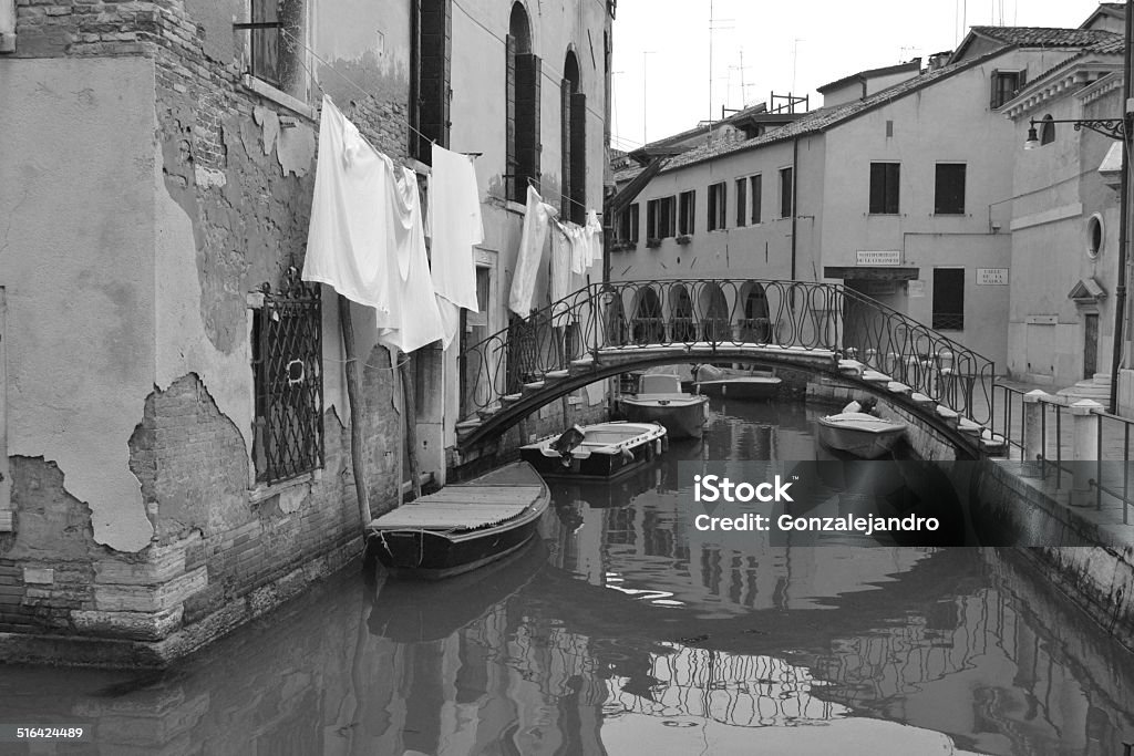 beautiful canal in Venice,  black and white sunrise in venice, boats ordinary people in solvency, linens, small bridge and old walls that make it unique to Venice, black and white Architecture Stock Photo