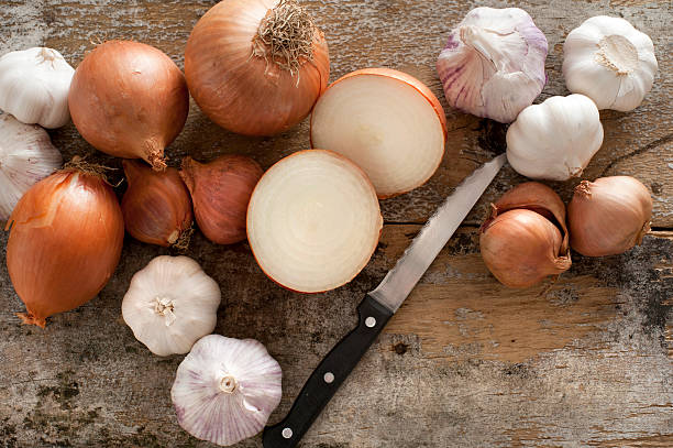 istock Whole and halved fresh uncooked garlic and onion 516425614