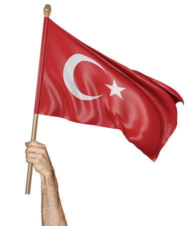 Man's hand raising the Turkish national flag high in the air, isolated against a white background.