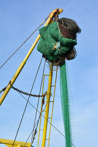 istock Fishing nets on a trawler against blue sky 516428256