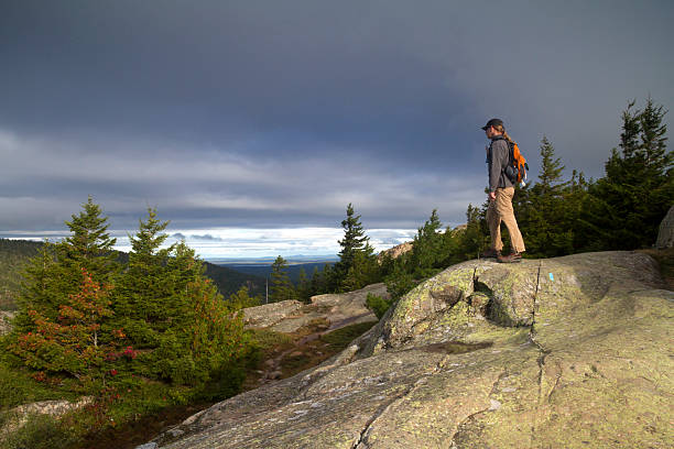 istock Hiker looking over mountains with stormy clouds 516441359