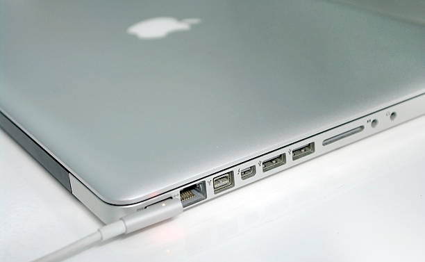 carregamento macbook pro computador, - macbook apple macintosh laptop apple computers imagens e fotografias de stock