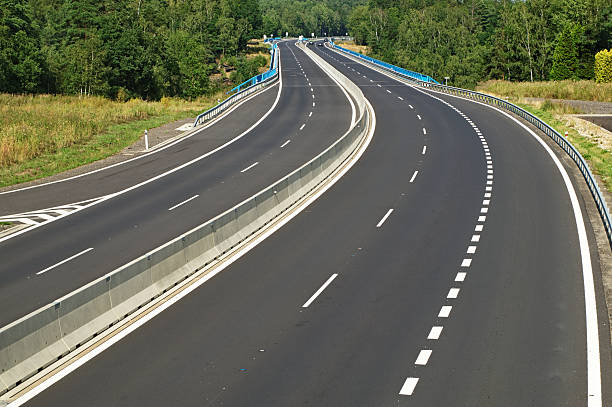 istock Empty highway disappearing into the trees in the forest 516441903