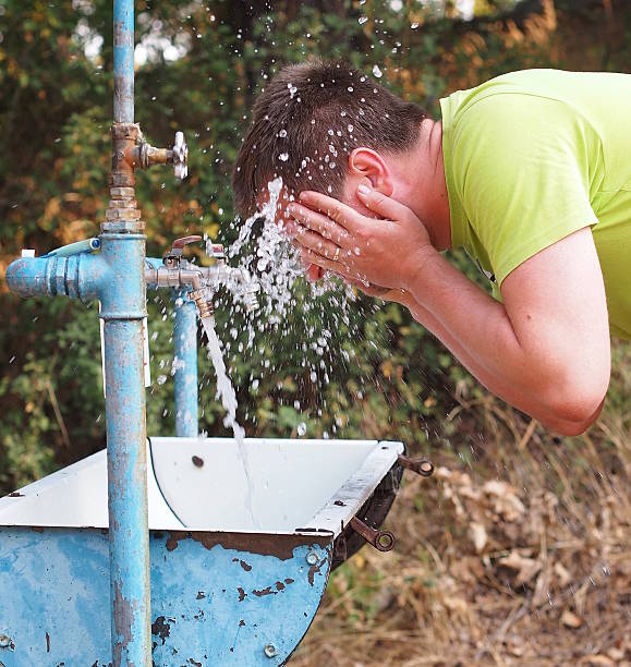 istock Man washing his face outdoor 516445490