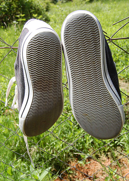 istock Drying sneakers on a wire fence 516446784