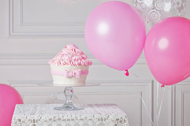 istock Festive cake and balloons. White and pink color 516446932