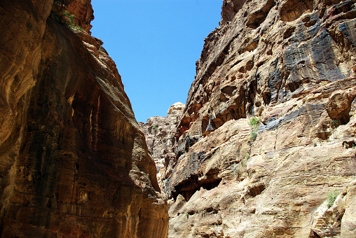 The long, hot road in the ancient city of Petra. Jordan. The road runs between the rocks and through narrow gorges. Ancient caves like home.