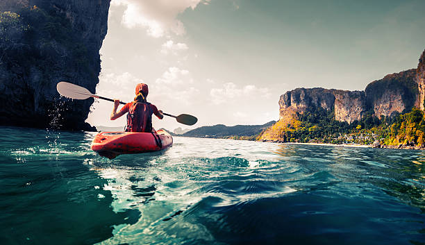 Lady with kayak Lady paddling the kayak in the calm tropical bay canoe photos stock pictures, royalty-free photos & images