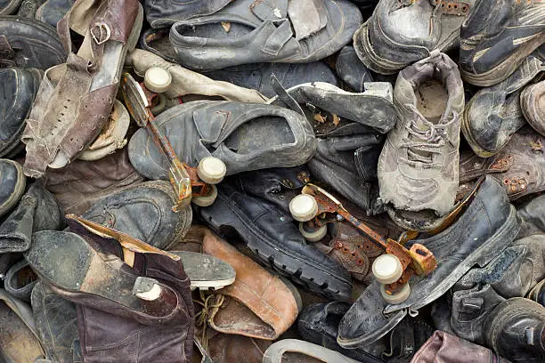 Photo of lot of old trash shoes with rusty roller skates