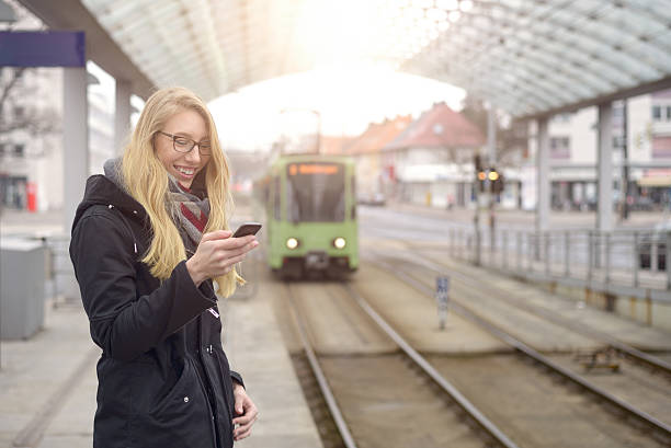 istock Woman at station with approaching train 516451954