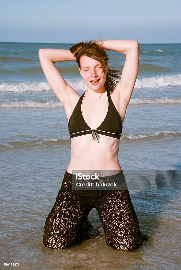Emotional woman on sea beach, Florida, USA Young beautiful woman in the rays of the rising sun, Redington Shores, Florida Adult Stock Photo