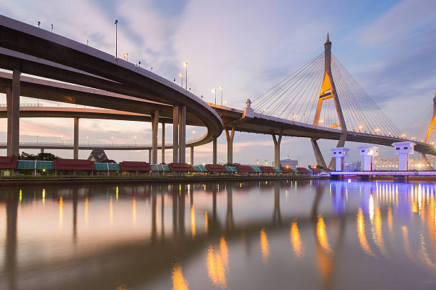 istock Twilight, Suspension bridge connect to elevated road 516455576