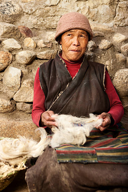 istock Tibetan woman combing wool in Upper Mustang 516457398