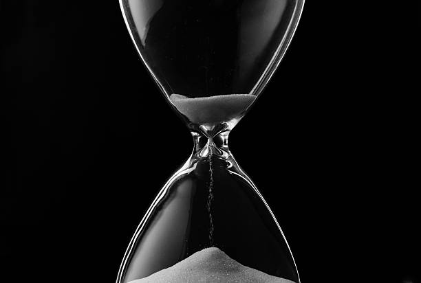 istock Sand trickling through the bulbs of an hourglass 516468357