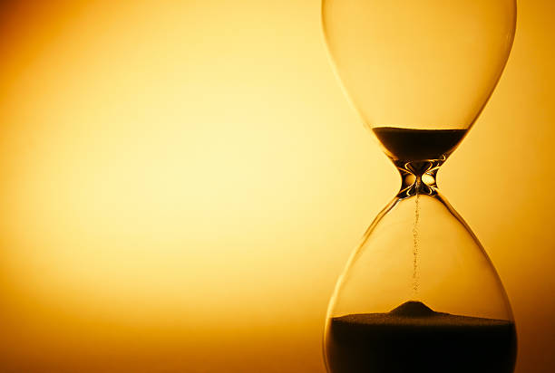 istock Sand passing through the bulbs of an hourglass 516484141