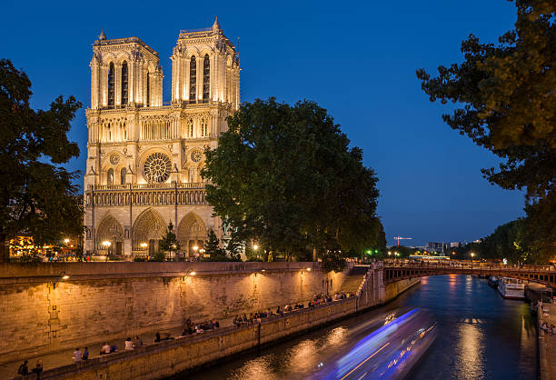 istock Notre Dame cathedral at dusk with blurry boat lights 516487761