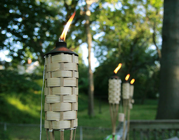 Tiki Burning Tiki lights once represented a goddess of fire and light, symbolizing the power of each of these elements. Now that power has been captured in a popular party decoration: the Tiki Torch.  tiki torch stock pictures, royalty-free photos & images