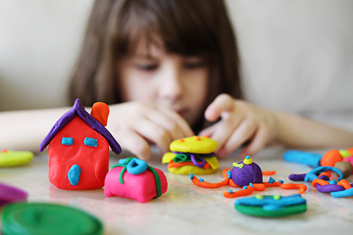 Little girl creating toys from plasticine