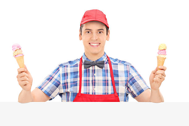 istock Male vendor holding two ice creams behind a panel 516487981