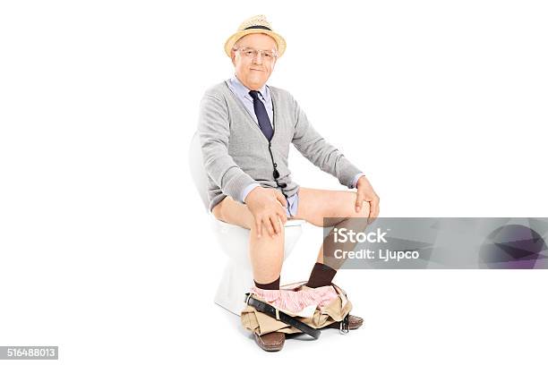 Studioaufnahme Der Glücklichen Senior Sitzen Auf Einer Toilette Stockfoto und mehr Bilder von Männer